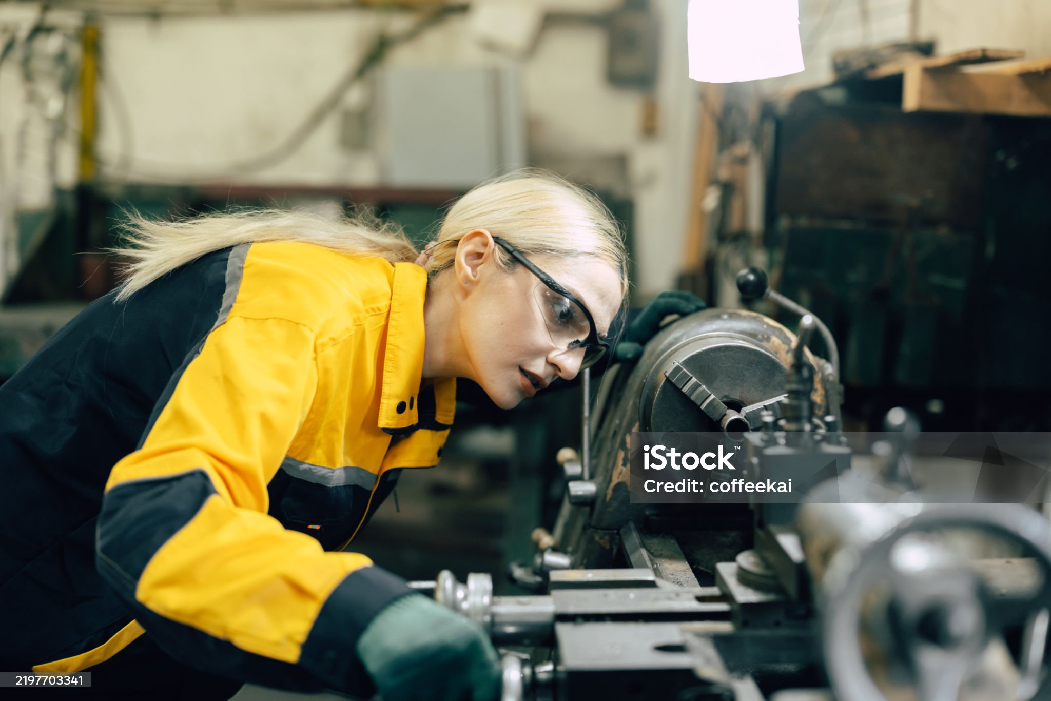 caucasian women worker working in heavy metal industry factory with steel part lathe machine